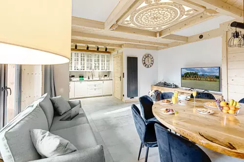 Salon z widokiem na kuchnię, stół dębowy oraz zdobienia ciesielskie